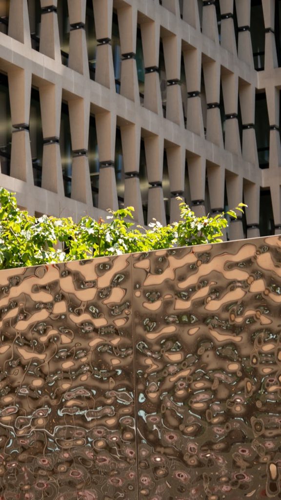 modern-urban-architecture-with-textured-metal-and-greenery-32656374